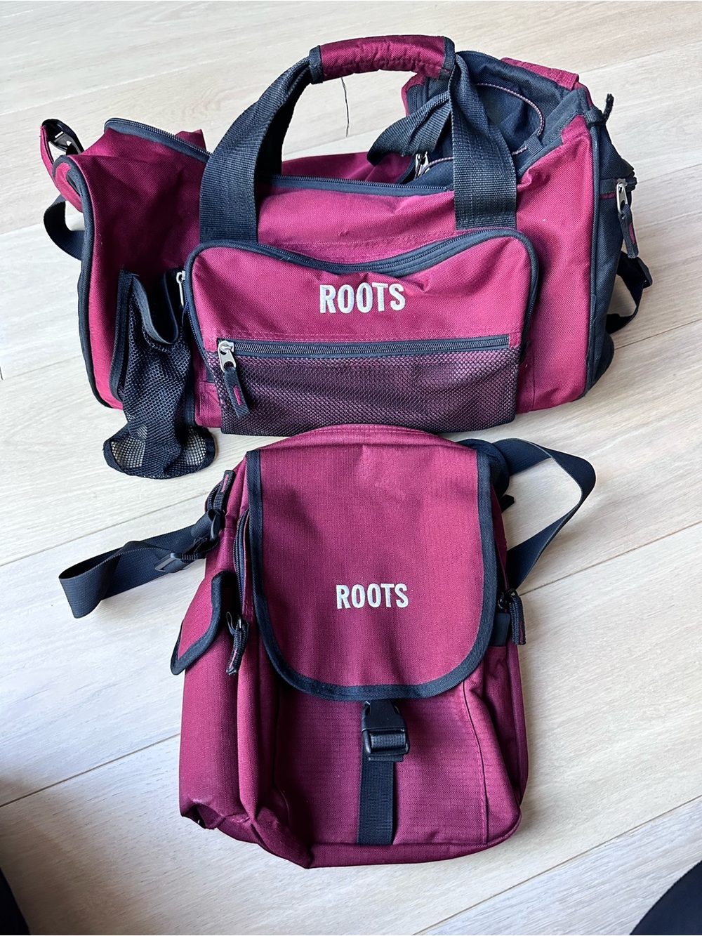 Roots Maroon and Black Travel Duffel Bag with match cross body bag.
